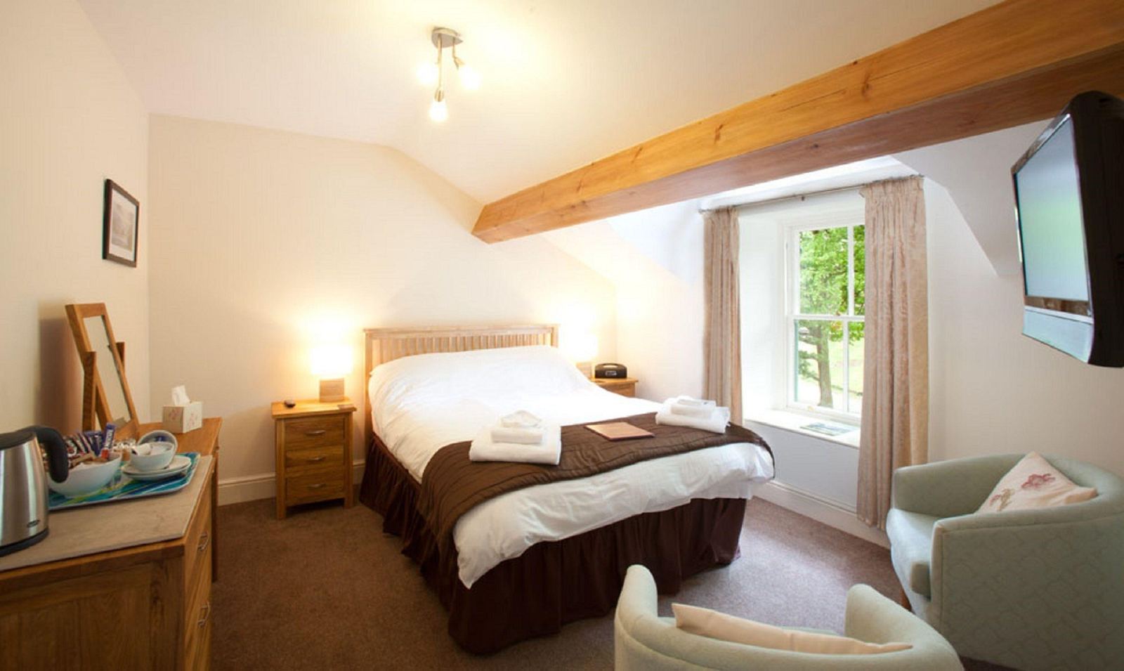 Double room with beamed ceiling and green armchair
