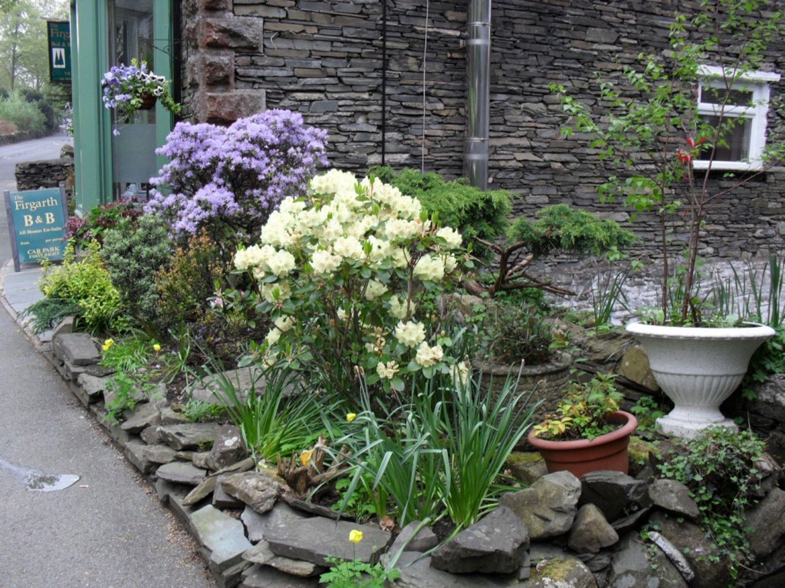 Front garden with stone wall and the house sign
